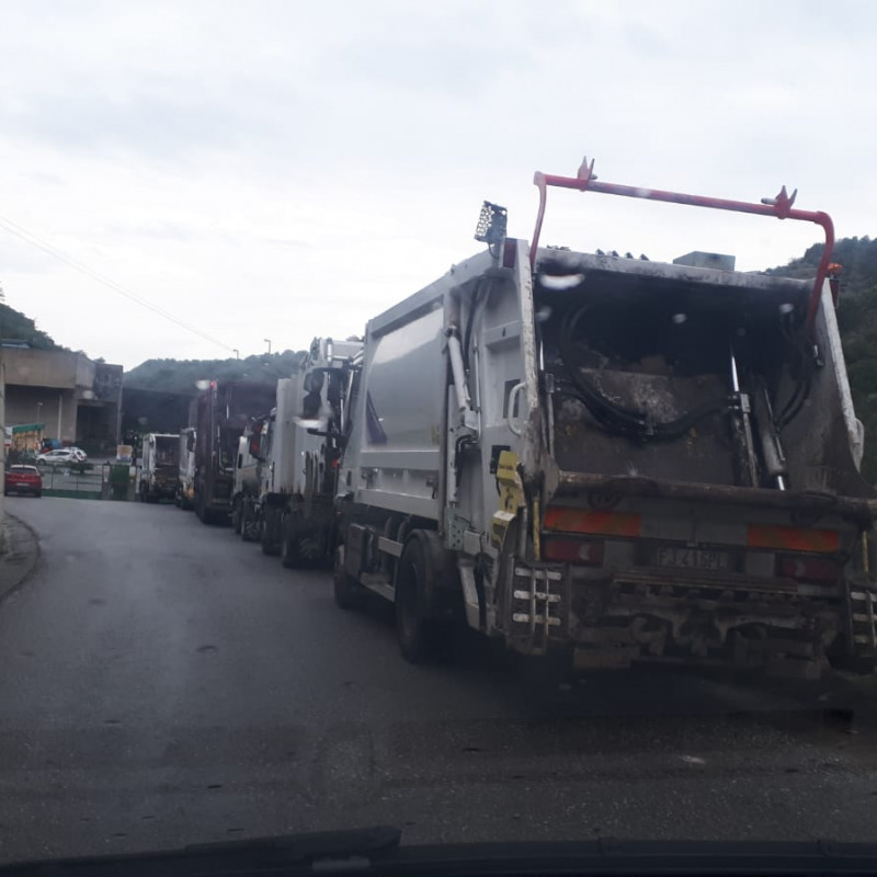 Una serie di camion in attesa di potere scaricare la spazzatura nell’impianto di Sambatello