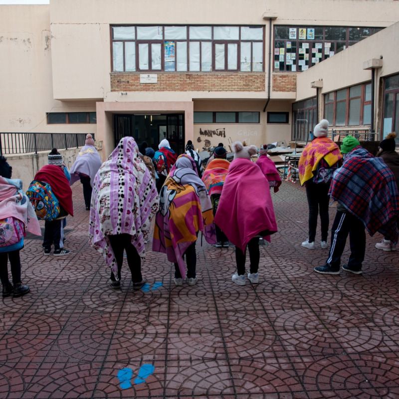 Gli allievi del plesso di Mosorrofa in attesa di entrare a scuola avvolti nei plaid per combattere il freddo in aula