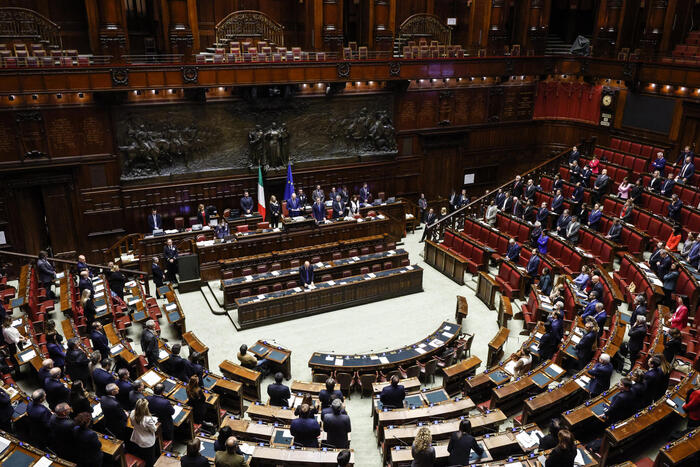 Aula della Camera dei deputati durante una votazione, deputati ai banchi, tensione politica visibile