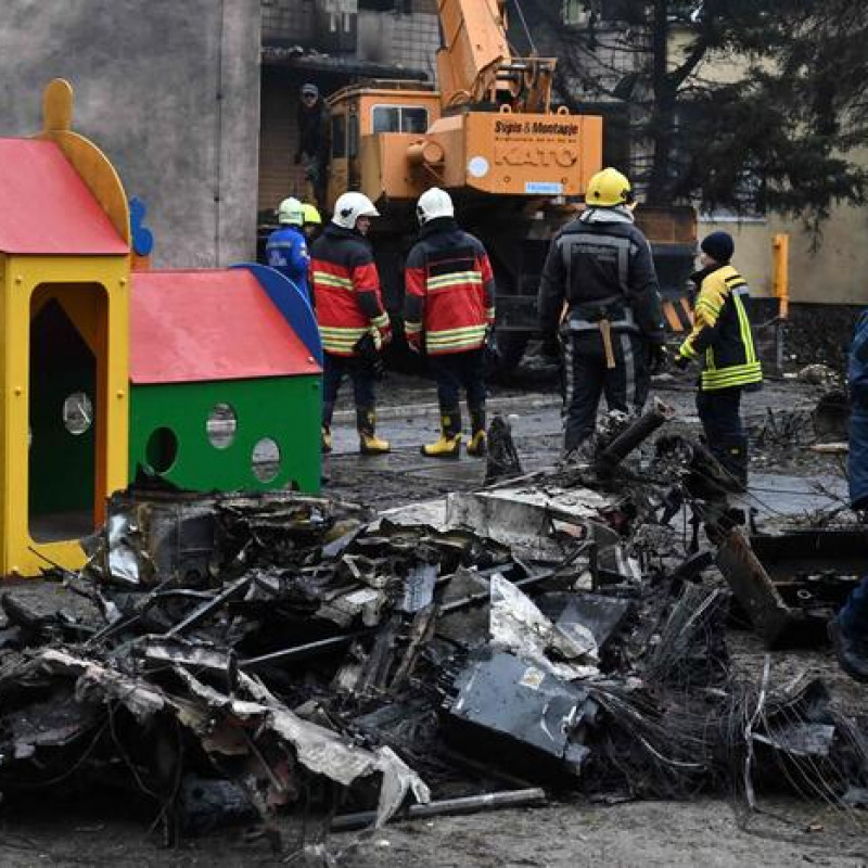 Firefighters work near the site where a helicopter crashed near a kindergarten in Brovary, outside the capital Kyiv, killing Sixteen people, including two children and Ukrainian interior minister, on January 18, 2023, amid the Russian invasion of Ukraine. (Photo by Sergei Supinsky / AFP)