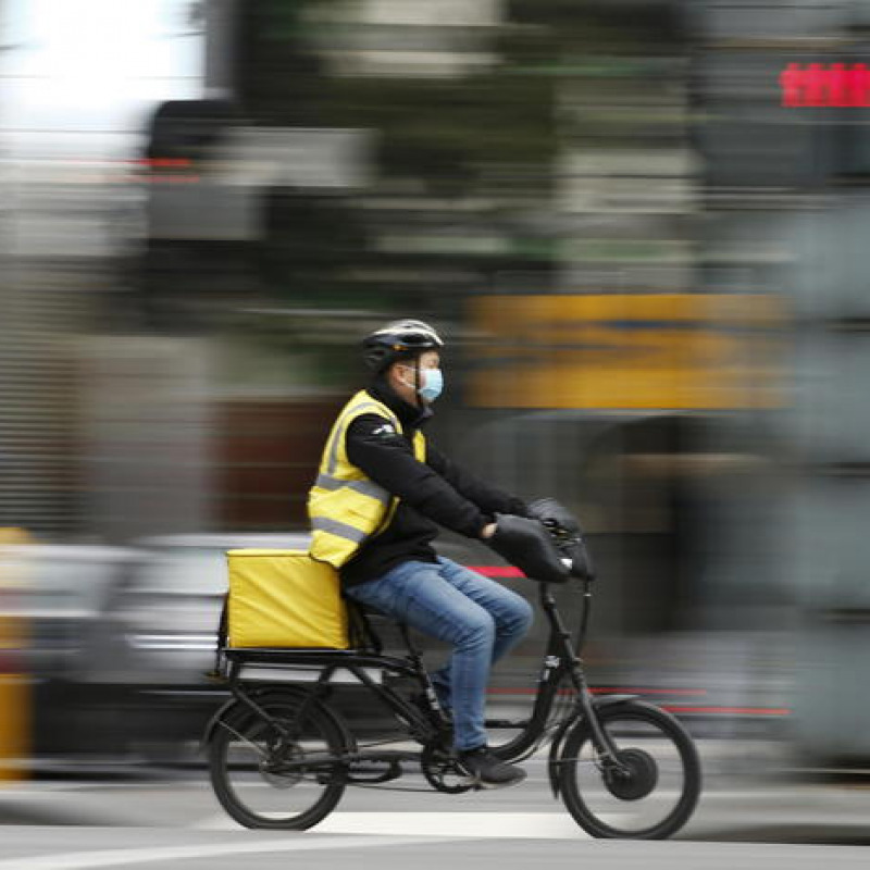 epa08507667 A photo taken using a slow shutter speed shows a delivery rider wearing a face mask in Melbourne, Australia, 25 June 2020. The Australian Defence Force (ADF) and other states have been called in to help Victoria tackle its rising number of coronavirus cases. EPA/DANIEL POCKETT AUSTRALIA AND NEW ZEALAND OUT