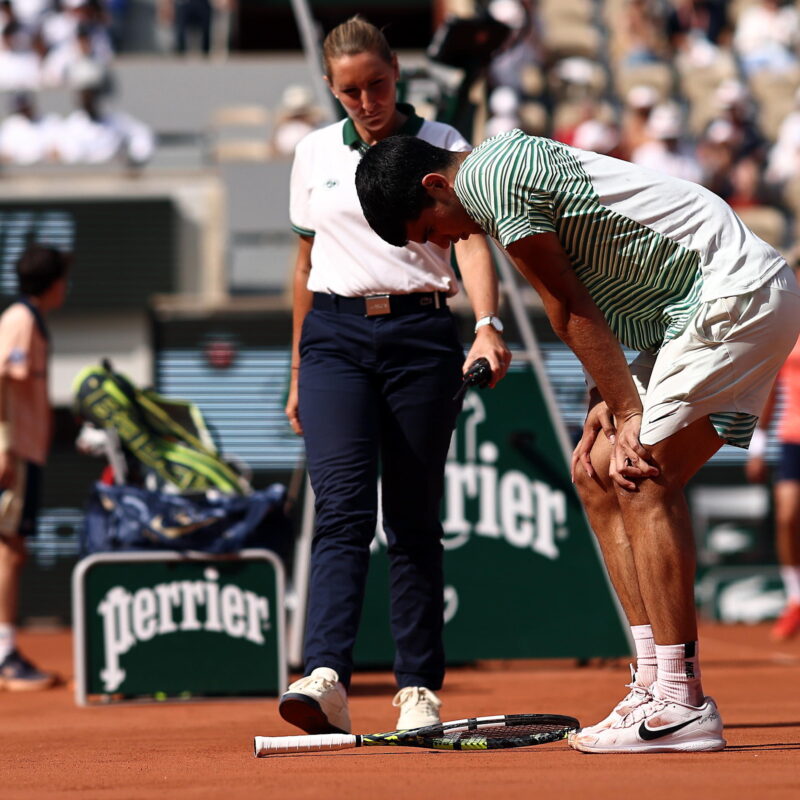 epa10681710 Carlos Alcaraz of Spain has problems with his legs as he plays Novak Djokovic of Serbia in their Men's semi final match during the French Open Grand Slam tennis tournament at Roland Garros in Paris, France, 09 June 2023. EPA/MOHAMMED BADRA