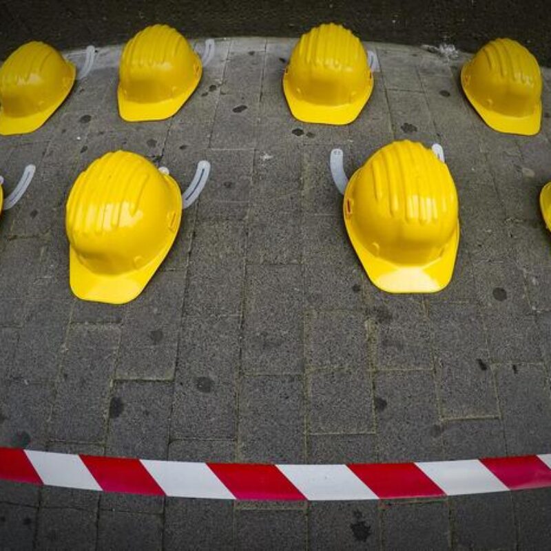 Iniziativa sindacale della Cisl di Napoli nella giornata mondiale per la sicurezza sul lavoro con l'esposizione su un marciapiede di 27 caschi gialli, lo stesso numero di morti sul lavoro registato nella provincia partenopea nel 2017, 27 aprile 2018. ANSA / CIRO FUSCO