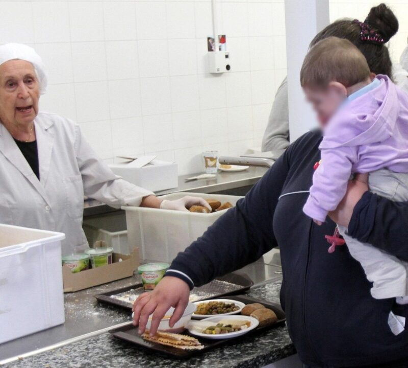 Una mamma con la sua bambina in fila in una mensa per l'assistenza ai bisognosi in un'immagine d'archivio. ANSA/MATTEO BAZZI