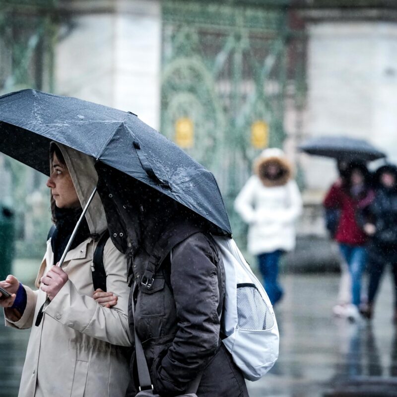 Turisti si riparano dalla pioggia con l'ombrello in piazza Castello, Torino, 29 marzo 2024. ANSA/TINO ROMANO