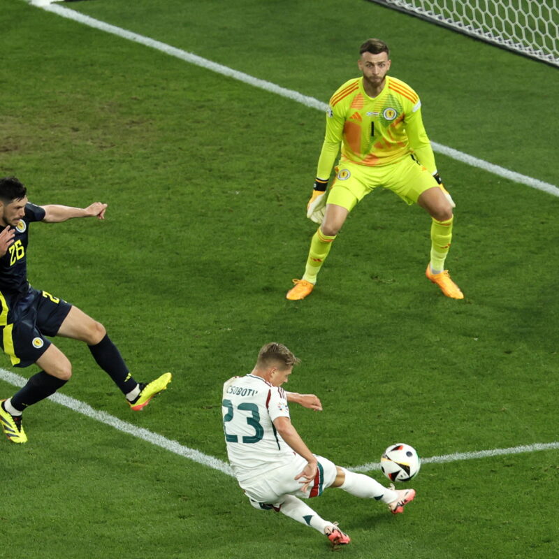 epa11433223 Kevin Csoboth of Hungary (C) in action on target against goalkeeper Angus Gunn (R) and Scott McKenna of Scotland during the UEFA EURO 2024 Group A soccer match between Scotland and Hungary, in Stuttgart, Germany, 23 June 2024. EPA/RONALD WITTEK