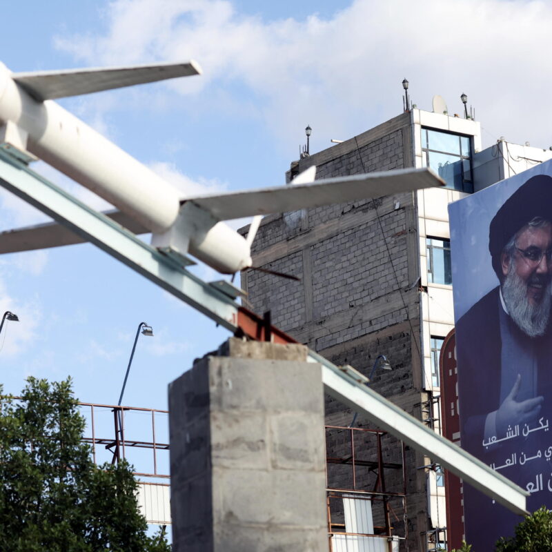 epa11675337 A Houthis-made mock drone on display in front of a billboard featuring a portrait of late Hezbollah leader Hassan Nasrallah, at a square in Sana'a, Yemen, 22 October 2024. Yemen's Houthis have claimed responsibility for launching a hypersonic ballistic missile at an Israeli military base east of Tel Aviv, in retaliation for Israel's military operations in Lebanon and the Gaza Strip, Houthis' military spokesman Yahya Sarea said in a statement. EPA/YAHYA ARHAB