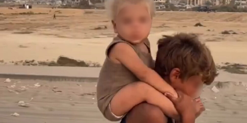 Gaza, immagini strazianti: il video del piccolo in lacrime che porta sulle spalle la sorellina diventa simbolo dell’esodo