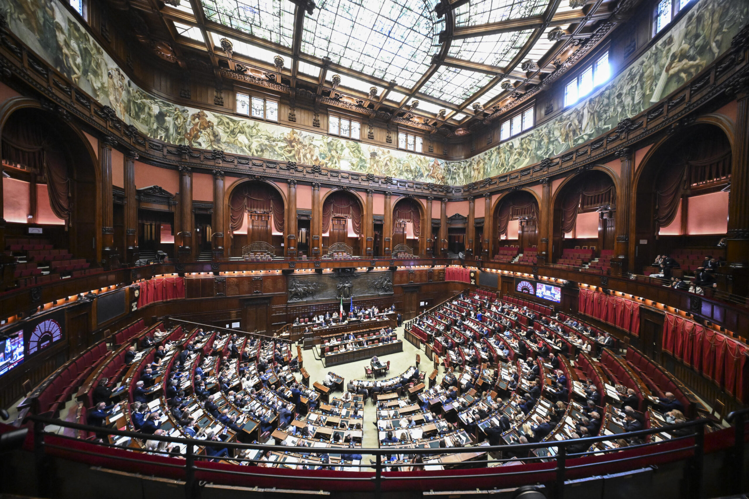 Aula della Camera dei deputati durante una votazione, deputati ai banchi, tensione politica visibile, immagine di approfondimento